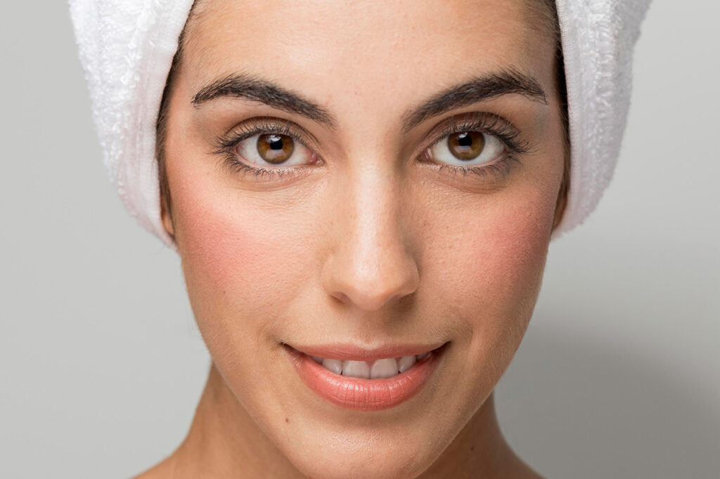 visage de femme avec une serviette sur la tete poru montrer les benefices du lait de chevre pour la peau