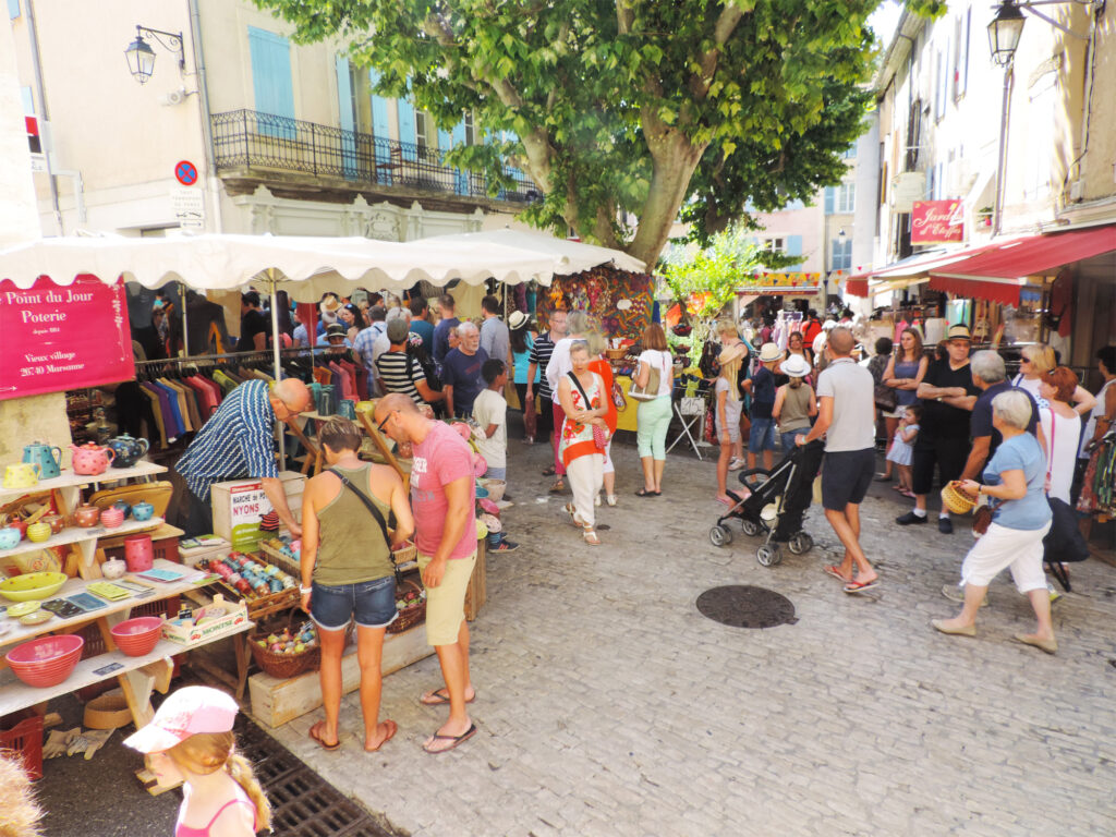 Scène de marché lors des Olivades à Nyons, présentant produits oléicoles et animations culturelles
